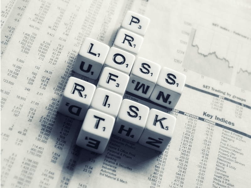 Scrabble-like cubes spelling the words ‘profit,’ ‘loss,’ and ‘risk’